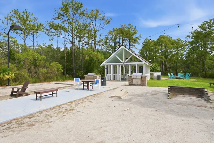 Charming outdoor recreational area with a modern pavilion, seating, and lush greenery, perfect for gatherings and relaxation.