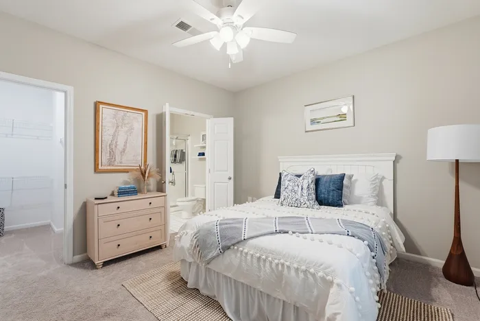 Inviting bedroom featuring elegant decor with a cozy bed, soft lighting, and an adjacent walk-in closet and ensuite bathroom.
