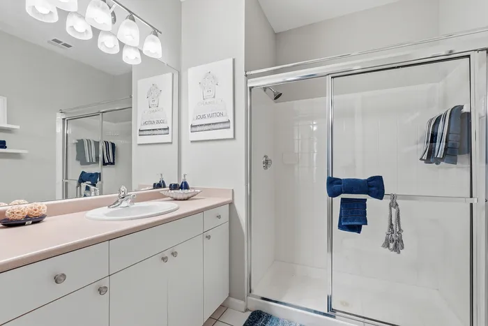 Elegant bathroom with modern fixtures, glass shower enclosure, and stylish decor accents.