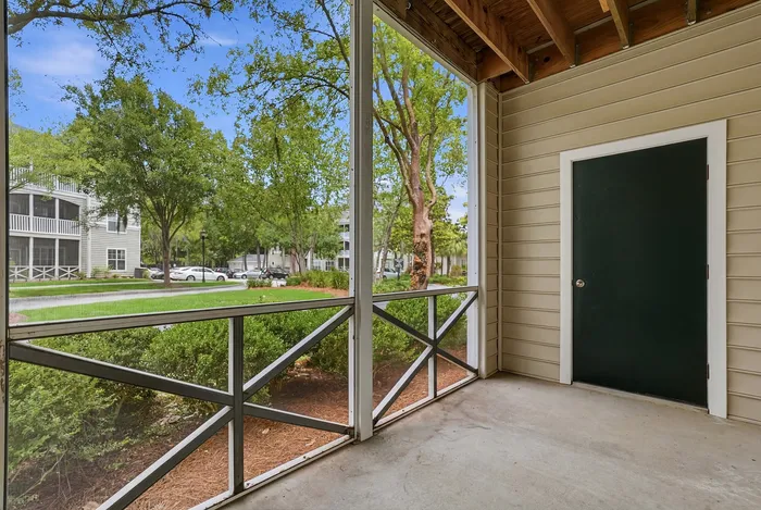 Charming screened patio with lush greenery views and modern exterior design.