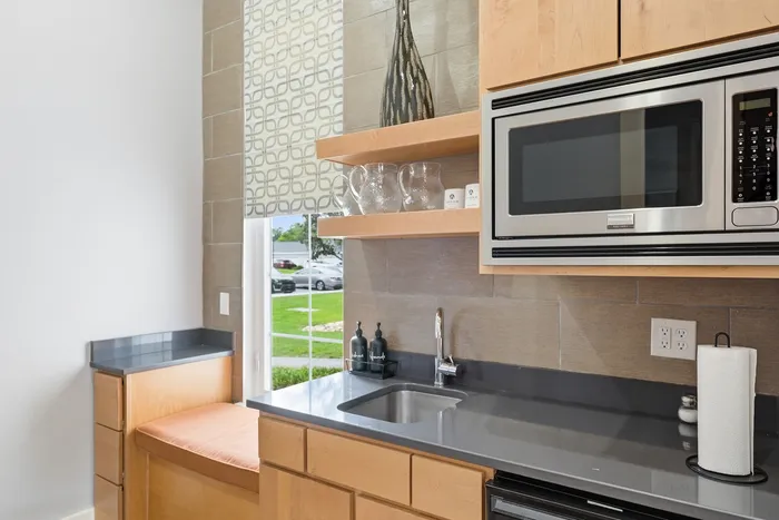 Modern kitchen with sleek cabinetry, stainless steel appliances, and a cozy breakfast nook overlooking a lush garden view.