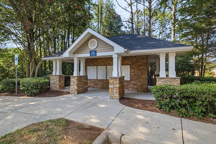 Charming stone mail house surrounded by lush greenery, exuding rustic elegance and convenience.