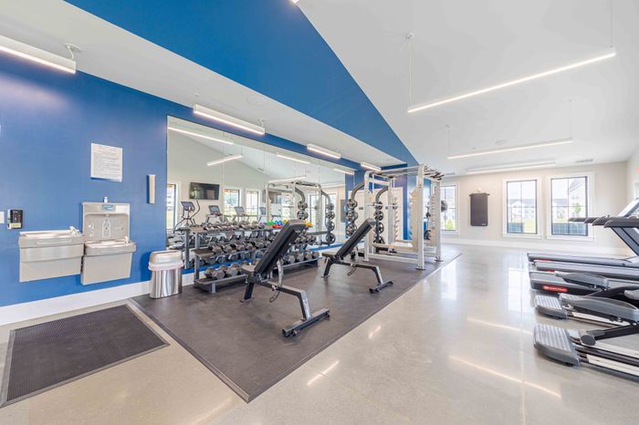 Modern fitness center with state-of-the-art gym equipment, bright interiors, and spacious workout areas.