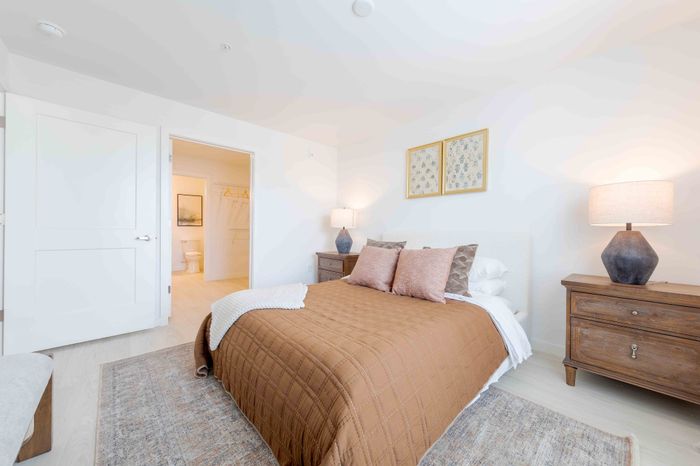 Bright and inviting bedroom with elegant decor, featuring a cozy bed, wooden nightstands, and soft lighting for a peaceful ambiance.
