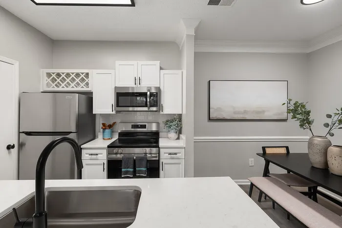 Modern kitchen design featuring stainless steel appliances, elegant cabinetry, and a chic dining area with stylish decor.