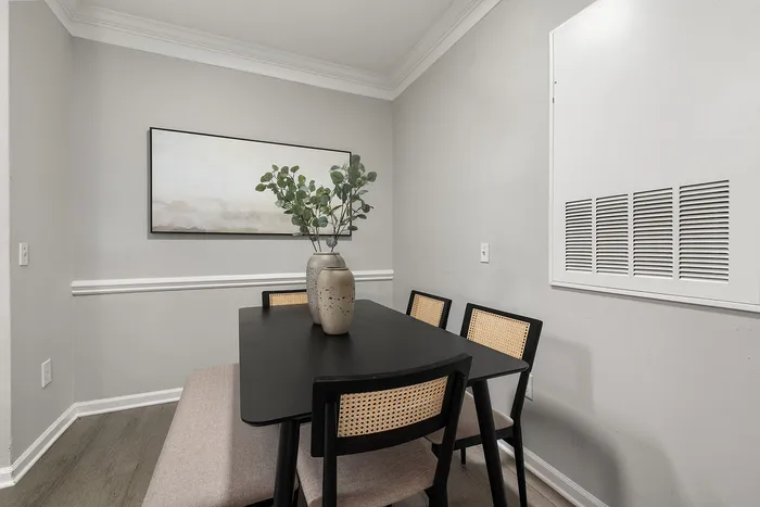 Chic dining nook showcasing a modern black table, stylish seating, and elegant decor with neutral tones.