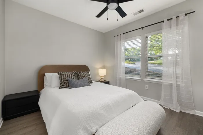 Inviting bedroom with a plush bed, elegant decor, and large windows offering ample natural light.