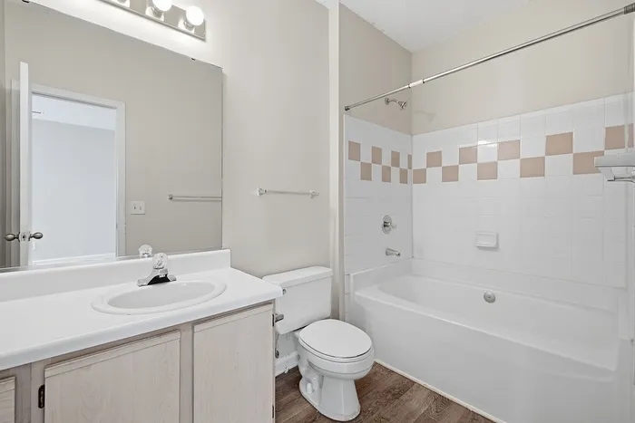 Modern bathroom with elegant tiled bathtub and sleek vanity in a refined apartment setting.