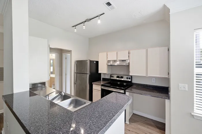 Modern kitchen featuring sleek granite countertops, stainless steel appliances, and stylish cabinetry.