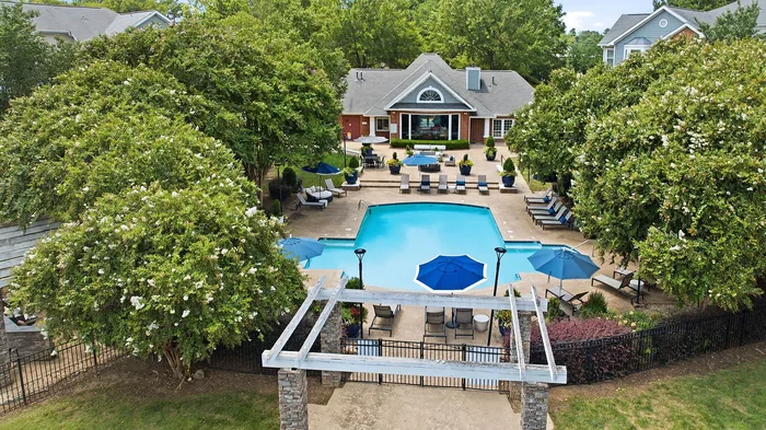Inviting apartment complex with lush greenery and a sparkling pool, perfect for relaxation and outdoor gatherings.