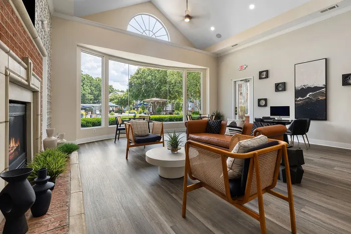 Inviting living room with large windows, modern seating, and a cozy fireplace, offering a bright and stylish retreat.