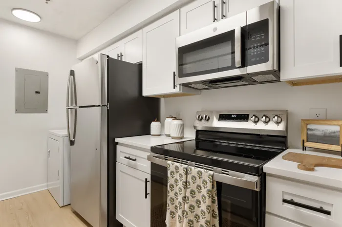 Modern kitchen with sleek stainless steel appliances, stylish white cabinetry, and a cozy, inviting feel.