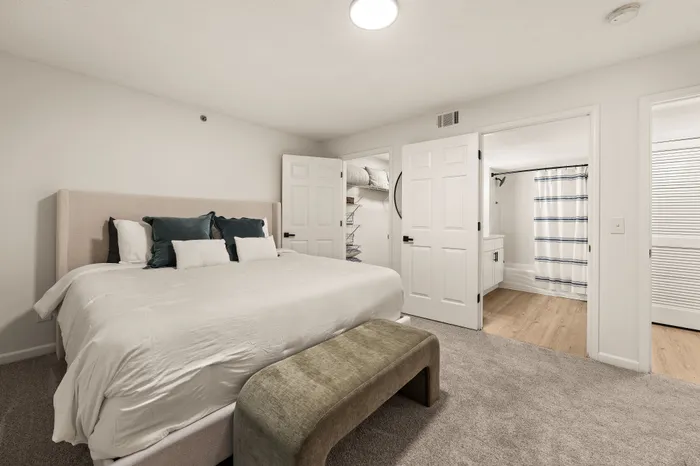 Inviting bedroom with a plush king-size bed, elegant linens, and a connected modern bathroom for ultimate comfort.