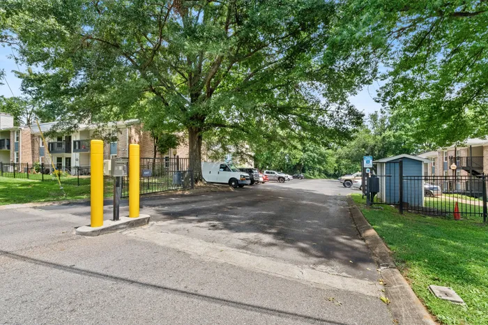 Welcoming apartment complex with ample parking, lush greenery, and a serene atmosphere, perfect for a peaceful lifestyle.