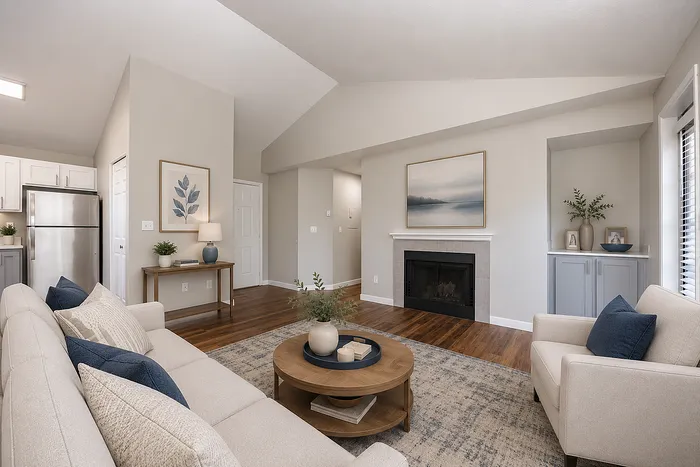 Inviting and elegant living room with modern beige seating, cozy fireplace, and stylish wooden flooring, perfect for relaxation and entertaining.