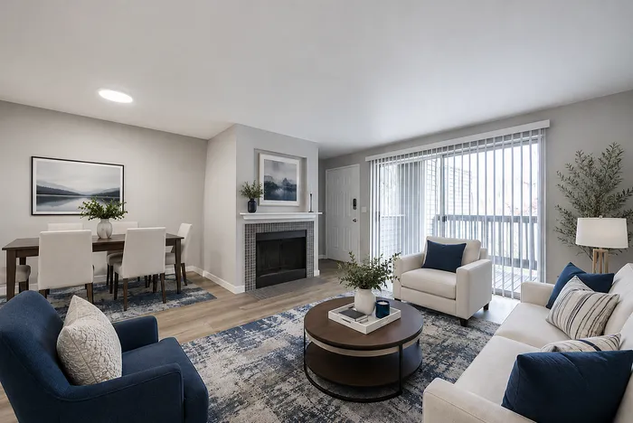 Inviting living room with modern decor, featuring a cozy fireplace, elegant dining area, and natural light from large patio doors.