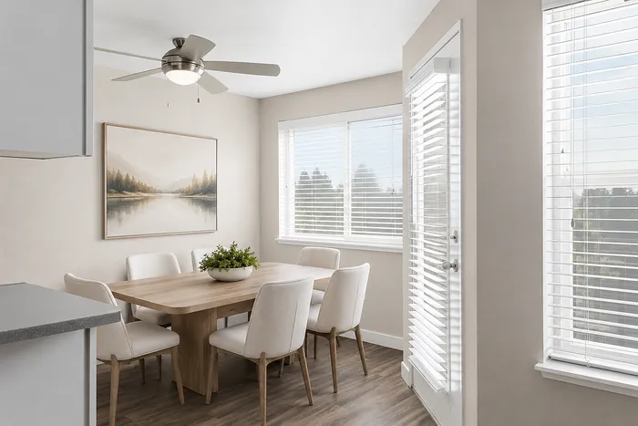 Bright and airy dining area with elegant wooden table, plush chairs, and large windows offering serene views.