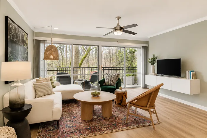Inviting living room with stylish decor, large windows offering a scenic view, and cozy seating area; perfect for relaxation.