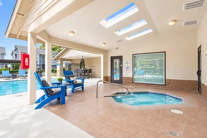 Inviting outdoor oasis with sunlit covered patio, cozy seating, and a sparkling poolside area for relaxation.