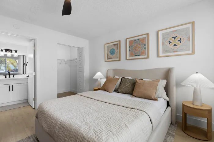 Inviting bedroom with modern decor, featuring a cozy bed, stylish artwork, and an adjoining bathroom with elegant fixtures.
