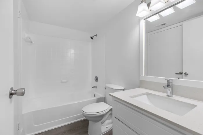 Modern bathroom featuring a sleek vanity, bathtub, and bright lighting for a refreshing ambiance.