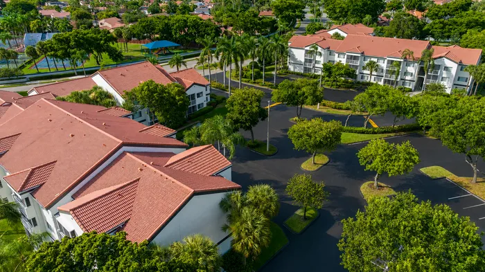 Beautiful aerial view of a residential community with lush green surroundings, red-tiled roofs, and well-maintained landscapes.