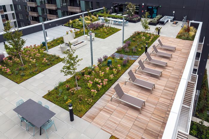 Luxurious rooftop terrace featuring lush gardens, stylish lounge chairs, and elegant outdoor seating areas.