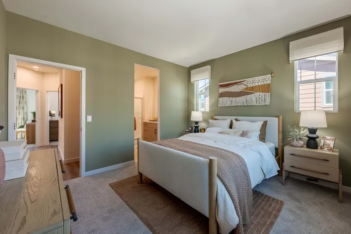 Townhome inviting bedroom with stylish decor, featuring a cozy bed, warm lighting, and tasteful wall art.