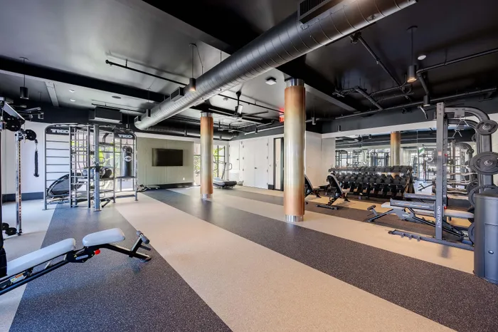Modern fitness center with state-of-the-art equipment, sleek design, and ample lighting for an optimal workout experience.