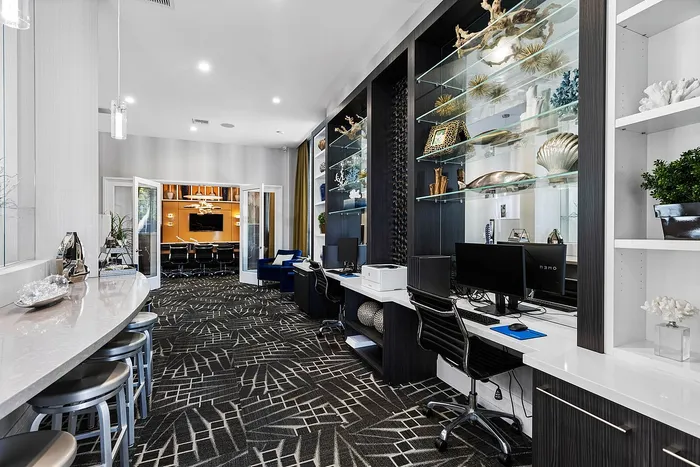 Modern and elegant co-working space featuring sleek workstations, stylish decor with artistic elements, and a cozy meeting room in the background.