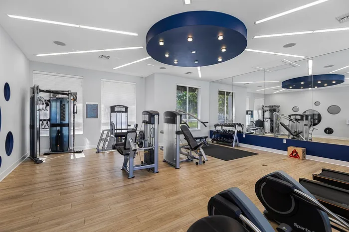 Modern fitness center with advanced gym equipment, sleek wooden flooring, and stylish lighting, perfect for an energizing workout.