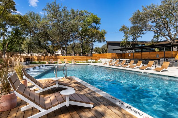 Poolside lounge seating beside the swimming pool at Perch Apartments.