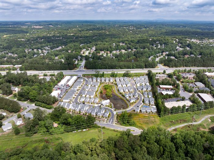 Picturesque aerial view of a vibrant residential community surrounded by lush greenery and scenic landscapes.