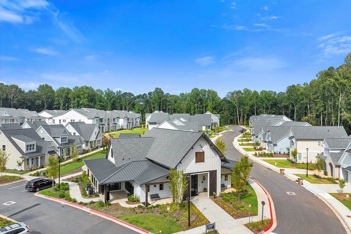 Inviting community view showcasing charming, modern homes with lush greenery and a serene neighborhood setting.