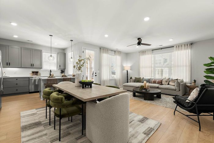 Elegant open-concept living and dining area with a modern kitchen, featuring chic lighting and a cozy atmosphere.