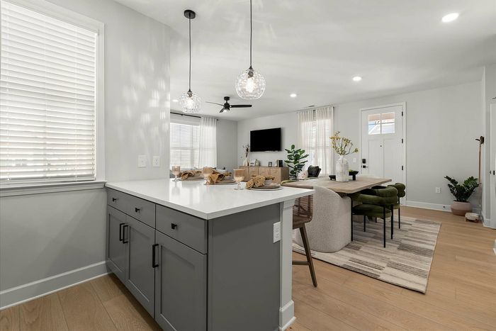 Modern open-concept kitchen and dining area with chic lighting, sleek countertops, and elegant decor creating a warm and inviting atmosphere.