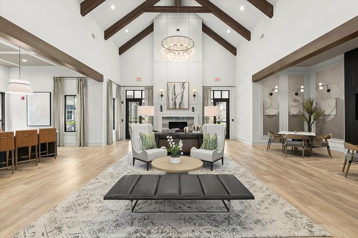 Luxurious living area with high vaulted ceilings, elegant chandelier, and stylish seating arrangement, perfect for relaxation and entertainment.