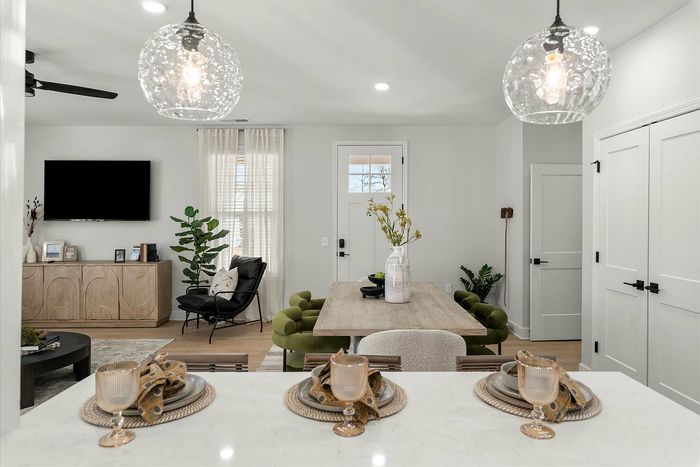 Elegant open-concept living and dining area with modern decor, featuring a chic dining table, stylish lighting, and a cozy seating area.