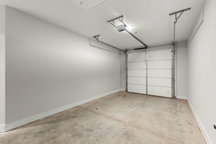 Spacious and clean modern garage with white walls, perfect for parking and storage solutions.