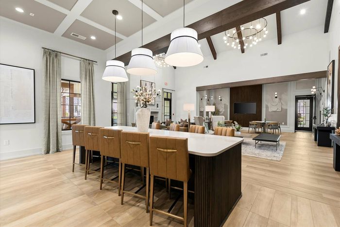 Elegant open-concept living space featuring a stylish dining area with modern lighting, plush seating, and luxurious decor accents.