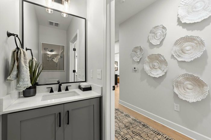 Chic bathroom with elegant fixtures, modern artwork, and a stylish hallway featuring decorative wall accents.