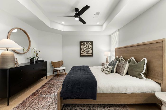 Elegant bedroom with modern decor, featuring a comfortable bed, stylish wooden furniture, and chic accent lighting.