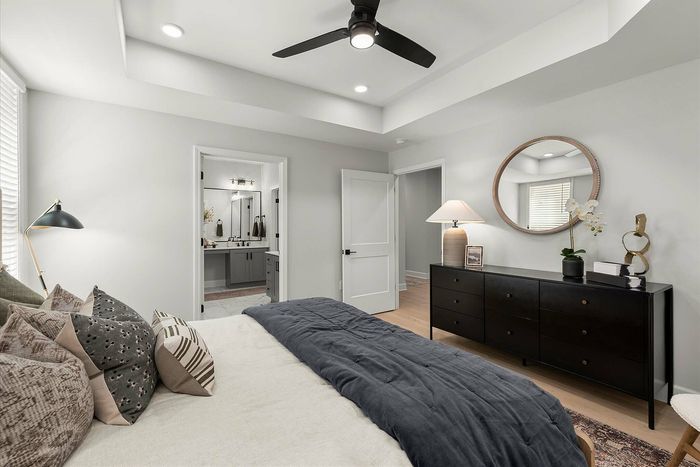Elegant bedroom with luxurious bedding, stylish black furniture, and a modern ensuite bathroom for ultimate comfort.