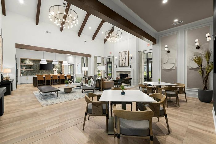 Luxurious open-concept living space with sleek modern furniture, elegant lighting, and inviting natural wood flooring.