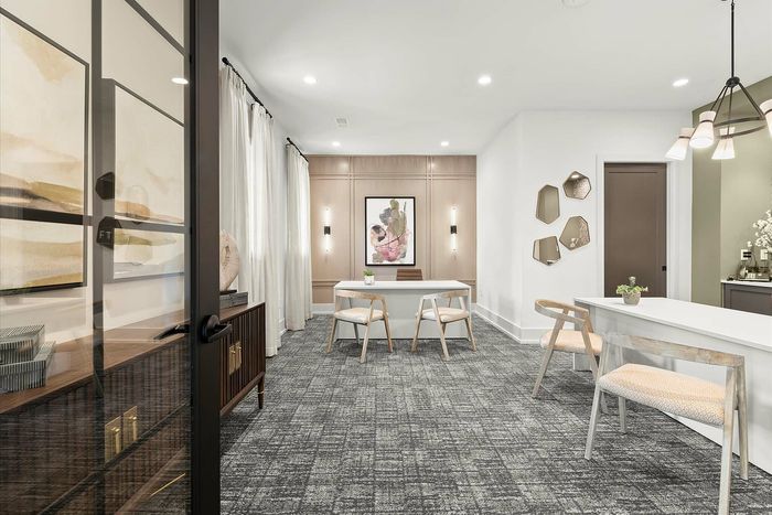 Chic and modern meeting room with sleek furniture, elegant wall art, and ambient lighting, creating a welcoming atmosphere.