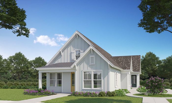 Charming modern farmhouse with a welcoming front porch, lush landscaping, and picturesque gable roof set against a clear blue sky.