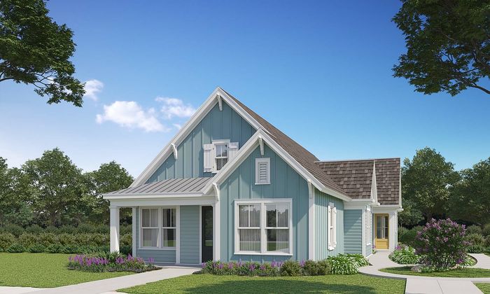 Charming blue cottage with inviting porch, surrounded by lush greenery and vibrant flowers under a clear blue sky.