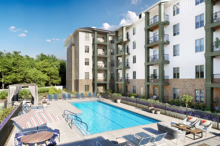 Luxurious apartment complex with a sparkling blue swimming pool, sun loungers, and vibrant garden setting for a perfect outdoor retreat.