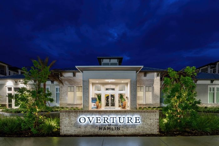 The entrance to Overture Hamlin active adult community in Winter Garden, FL, featuring a large sign and drop off loop.