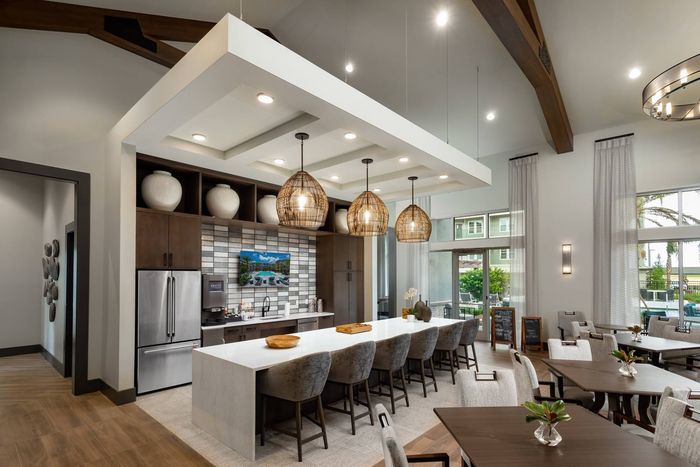 Resident lounge and dining area at our senior living community in Winter Garden, FL, featuring wood grain floor paneling.